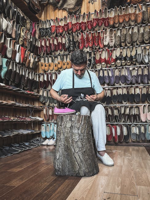 Turkish shoemaker crafting footwear in Gaziantep store with displayed handmade shoes.