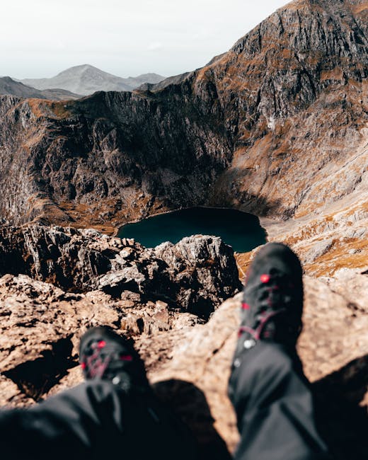 A stunning view from a rocky peak overlooking a hidden mountain lake in Wales, capturing the essence of adventure.