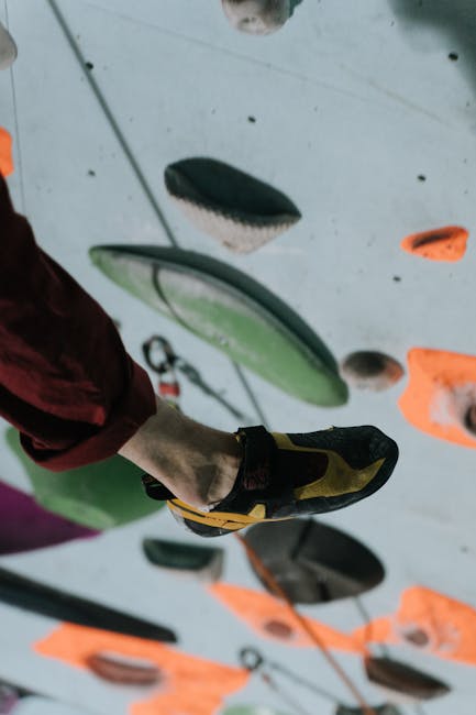 A focused shot of a climber's foot on a colorful indoor climbing wall, showcasing technique.