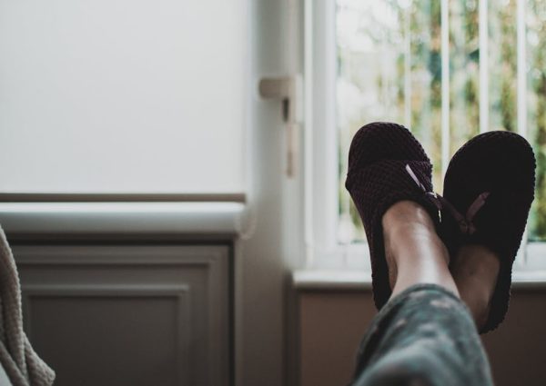 A cozy, relaxed atmosphere with feet in slippers up by a window, perfect for leisure and tranquility.